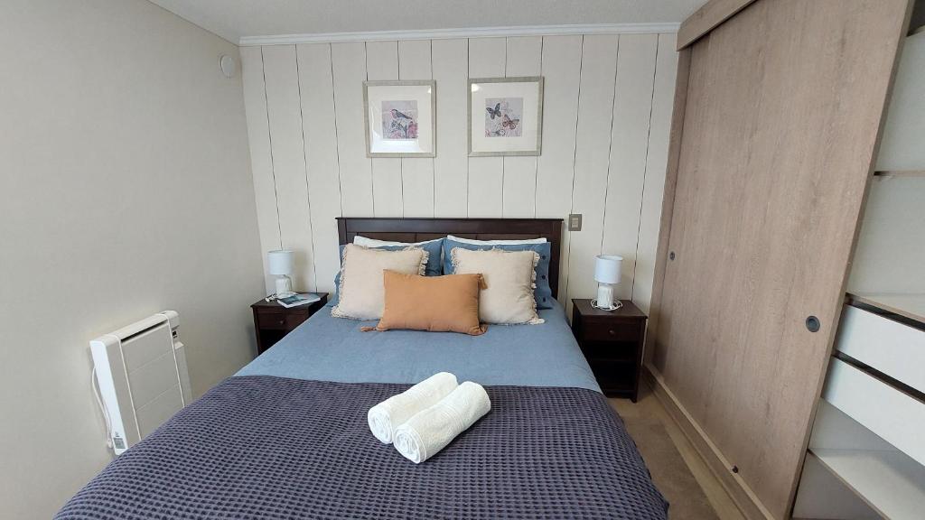 a bedroom with a blue bed with two night stands at Hermoso depto en Vista Cordillera II Puerto Montt in Puerto Montt
