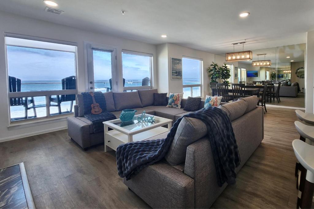 a living room with a couch and a table and windows at Modern Coastal Escape Breathtaking Ocean in Imperial Beach