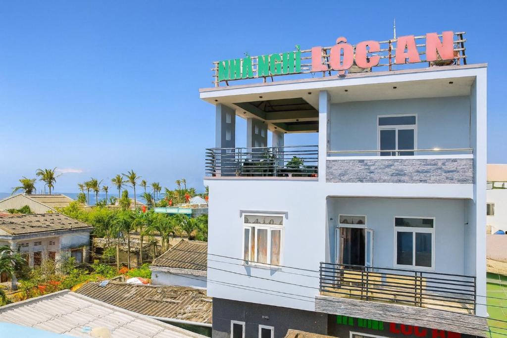 a white building with a sign on top of it at Lộc An Lý Sơn Motel in Ly Son