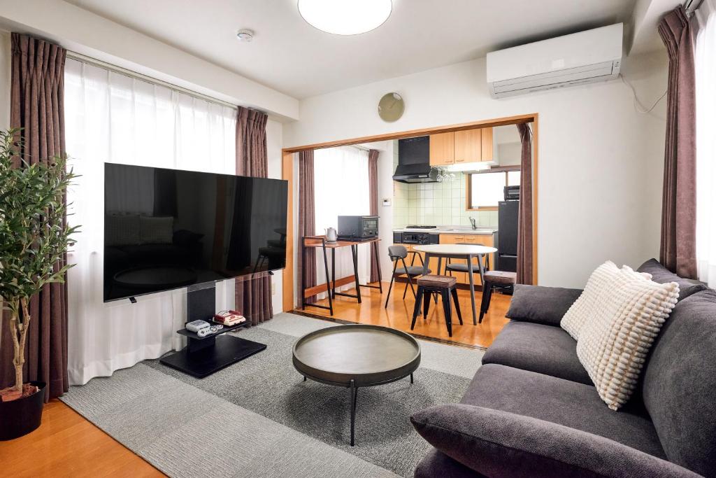 東京にあるとまりーとStay 西五反田のソファと薄型テレビのあるリビングルーム