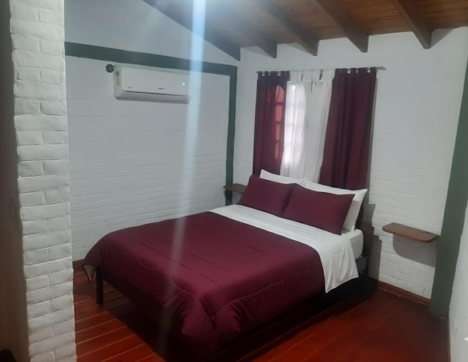 ein Schlafzimmer mit einem großen Bett mit einer roten Decke in der Unterkunft La casa de milac in Mina Clavero