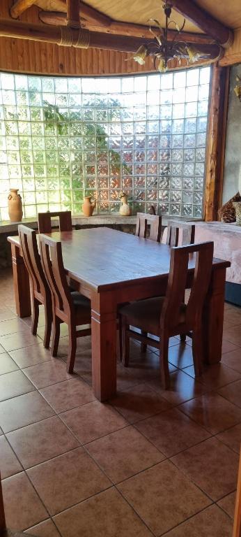 a large wooden table and chairs in a room at Cabaña Rústica in El Cerrillo