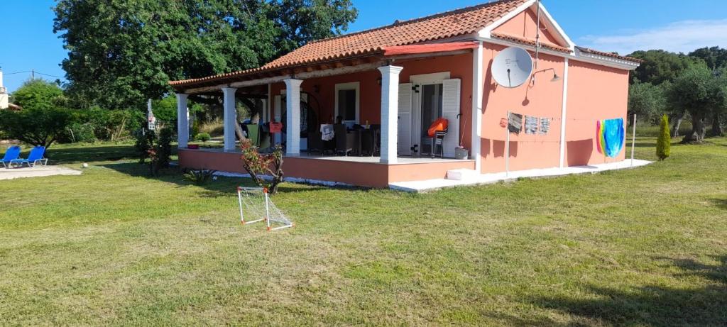 a small pink tiny house in a yard at Detached Vacation House with sea views at Chalikounas in Halikounas