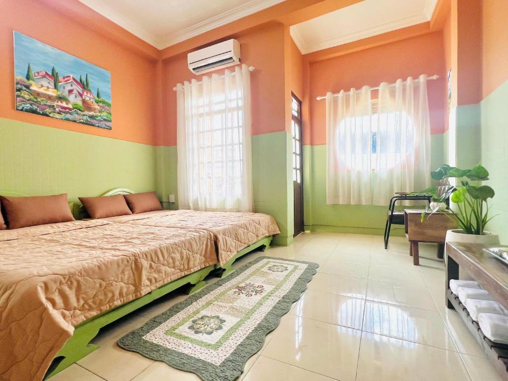 een slaapkamer met oranje en groene muren en een bed bij An Homestay CN2 in Ấp Bình Hưng