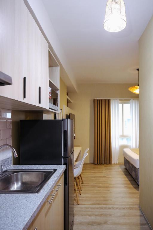 a kitchen with a sink and a refrigerator at The Studio Haven in Bacolod