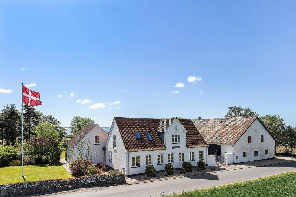a white house with a flag in front of it at FY285-Faaborg-Egsgyden-35 in Fåborg