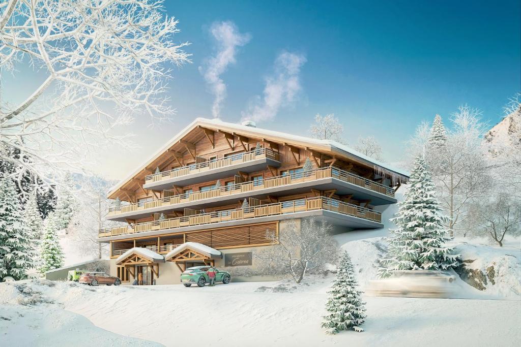 ein großes Gebäude im Schnee mit schneebedeckten Bäumen in der Unterkunft Le CAIRNE Chalet Residence in La Chapelle-dʼAbondance