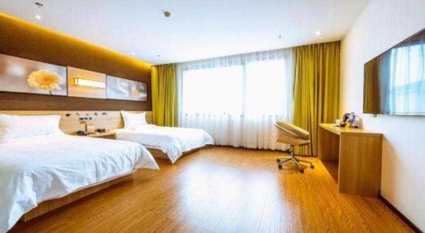 a hotel room with two beds and a window at IU Hotel Chongqing Jiangbei International Airport in Chongqing