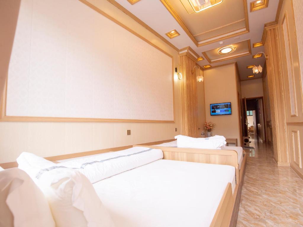 a hospital room with two beds and a projection screen at Nhà Nghỉ Quyền Ly in Mèo Vạc