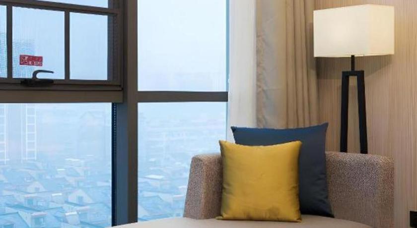 長沙市にあるEcharm Hotel Changsha Gaoqiaoのソファ、ランプ、窓が備わる客室です。