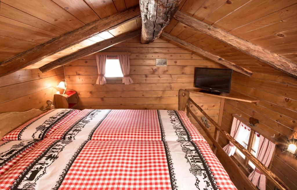 a bedroom with a bed in a wooden cabin at Hotel Romantica in Zermatt