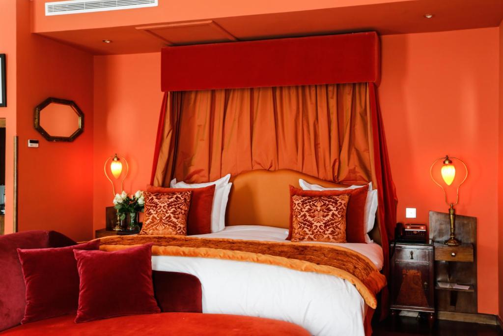 a bedroom with a large bed with orange walls at Hôtel particulier Le DOGE - Relais & Châteaux in Casablanca