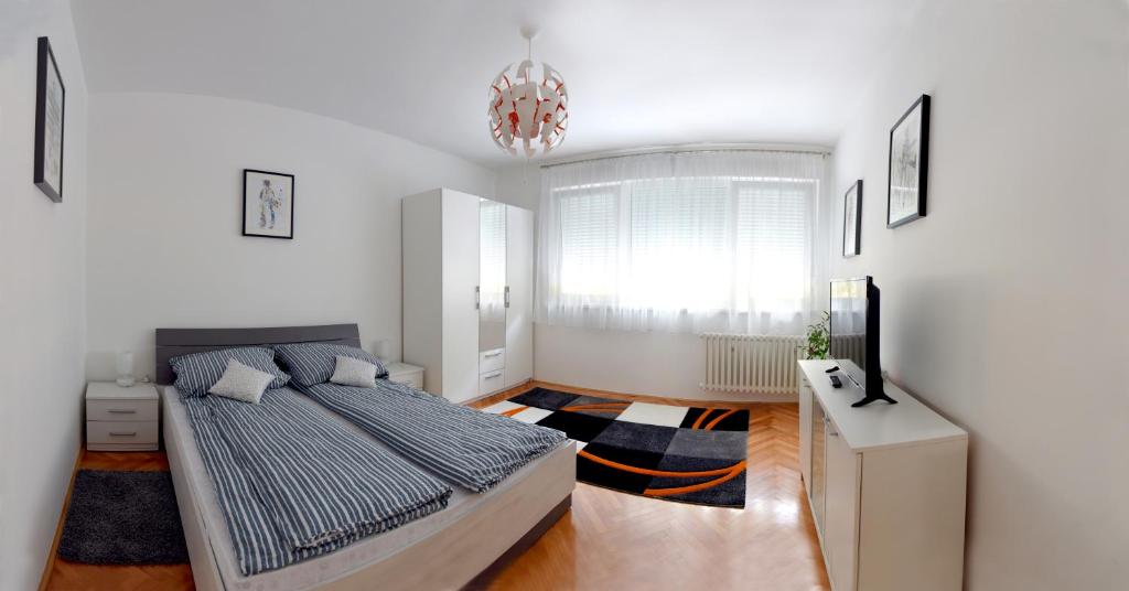 sypialnia z łóżkiem i żyrandolem w obiekcie Apartmani Vedmar w Zagrzebiu