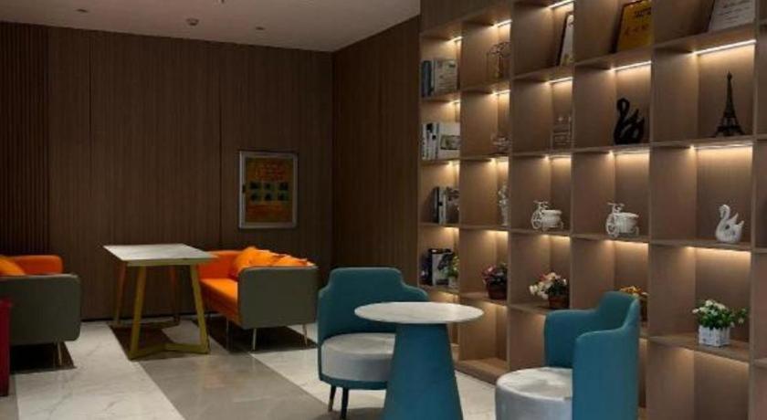 une salle d'attente avec une table et des chaises et une table et un inventaire dans l'établissement UP and IN Hotel Jiangxi Nanchang City Nanchang County Liantang Zhong Avenue Huarunwanjia, à Nanchang County