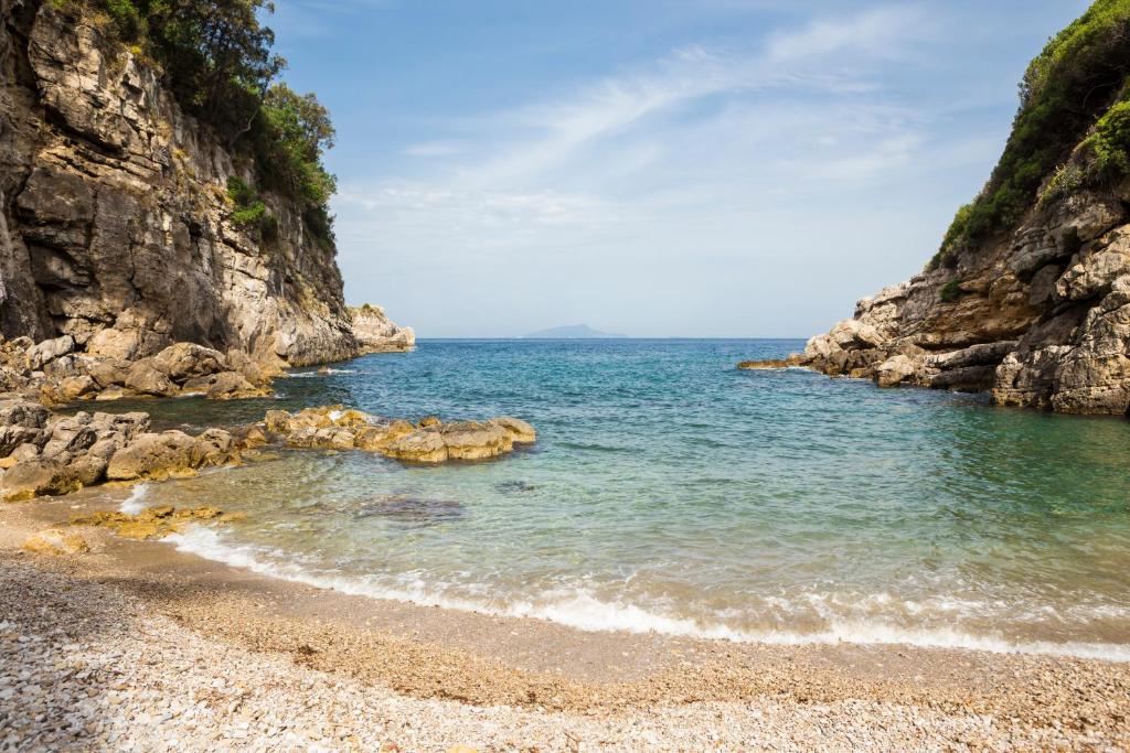 a beach with a rocky shore and the ocean at Relais Regina Giovanna in Sorrento