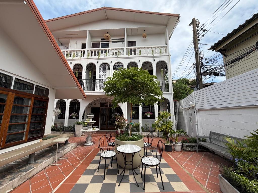 a patio with tables and chairs in front of a building at Bangkok Neighborhouse - Guesthouse in Bangkok