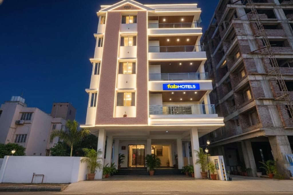 a tall white building with a sign on it at FabHotel Prime Athiti Delight Stay in Pune