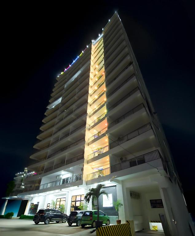 a tall building with cars parked in front of it at Kandi Heaven in White Tower in Angeles