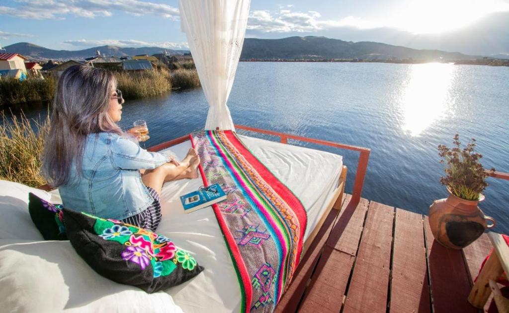 a young girl sitting on a boat on the water at Sol del Titikaka Lodge in Puno