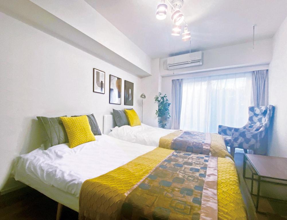 a bedroom with two beds and a table and a chair at -シーフォルム京急蒲田-Entire Unit in Tokyo