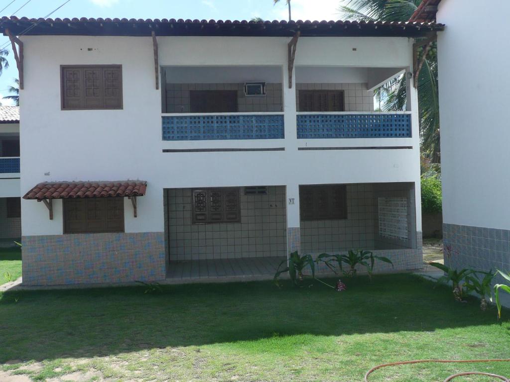 a white house with a yard in front of it at Privê Village Maragogi in Maragogi