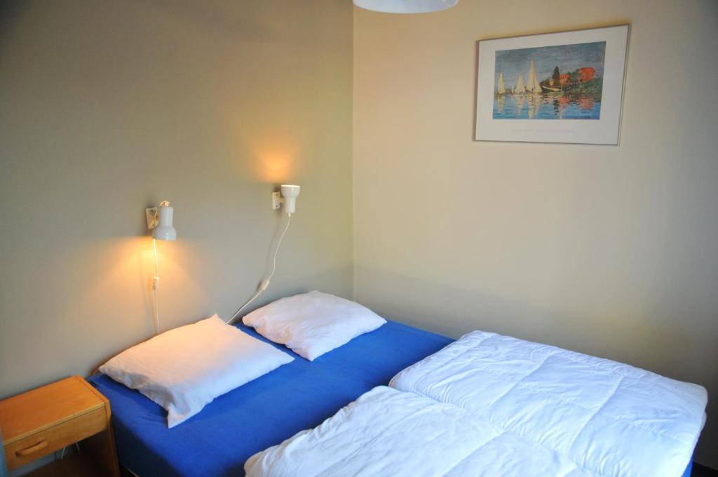 Hastière-par-delàにあるVillage de vacances Waulsortのベッドルーム1室(ベッド1台付)、壁にランプが備わります。