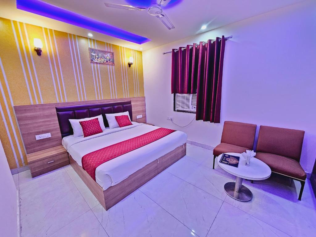 a bedroom with a bed and a table and a chair at Hotel Goodwill Stay Near Delhi Airport in New Delhi