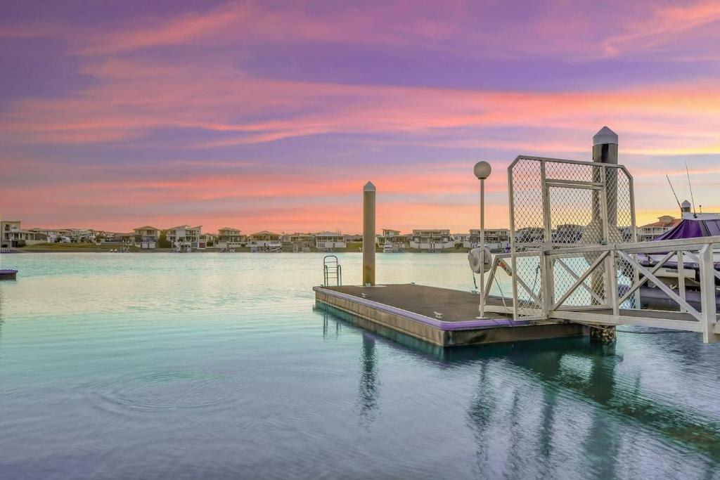 un muelle sobre un cuerpo de agua con puesta de sol en Waterfront-Bay View, en Port Macquarie