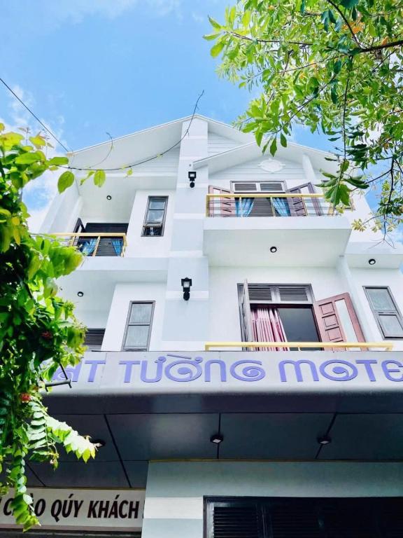 a white building with a sign on it at Cát Tường Homestay in Danang