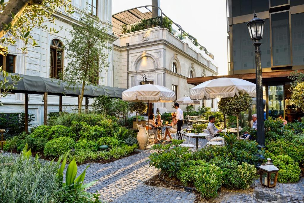 a courtyard with people sitting at tables and umbrellas at Soho House Istanbul in Istanbul