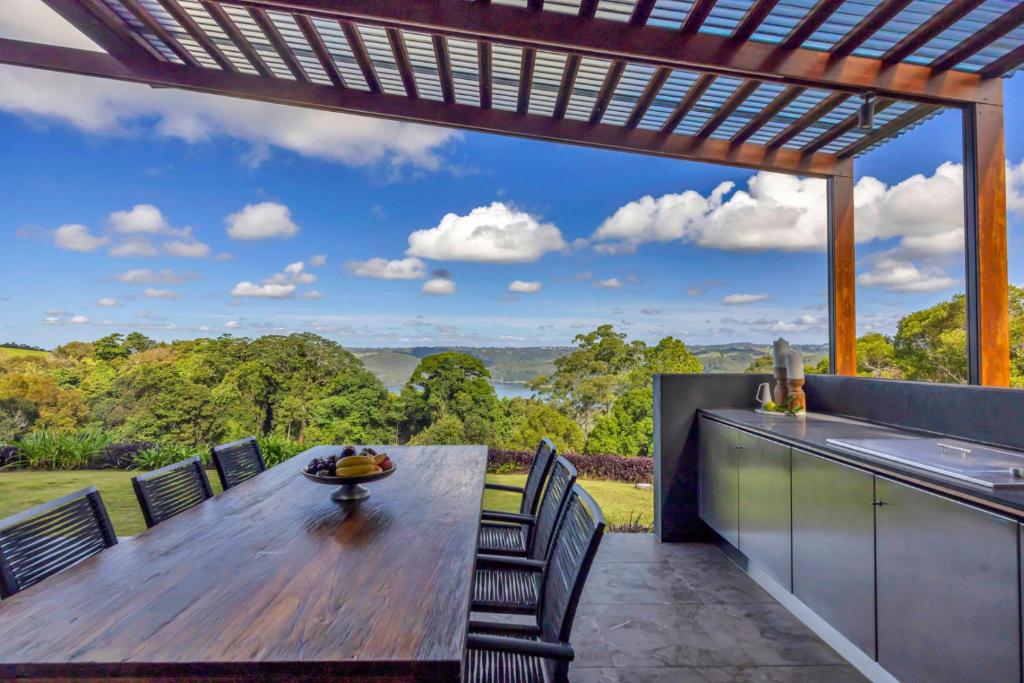 an outdoor kitchen with a wooden table and chairs at The Haven Montville in Montville