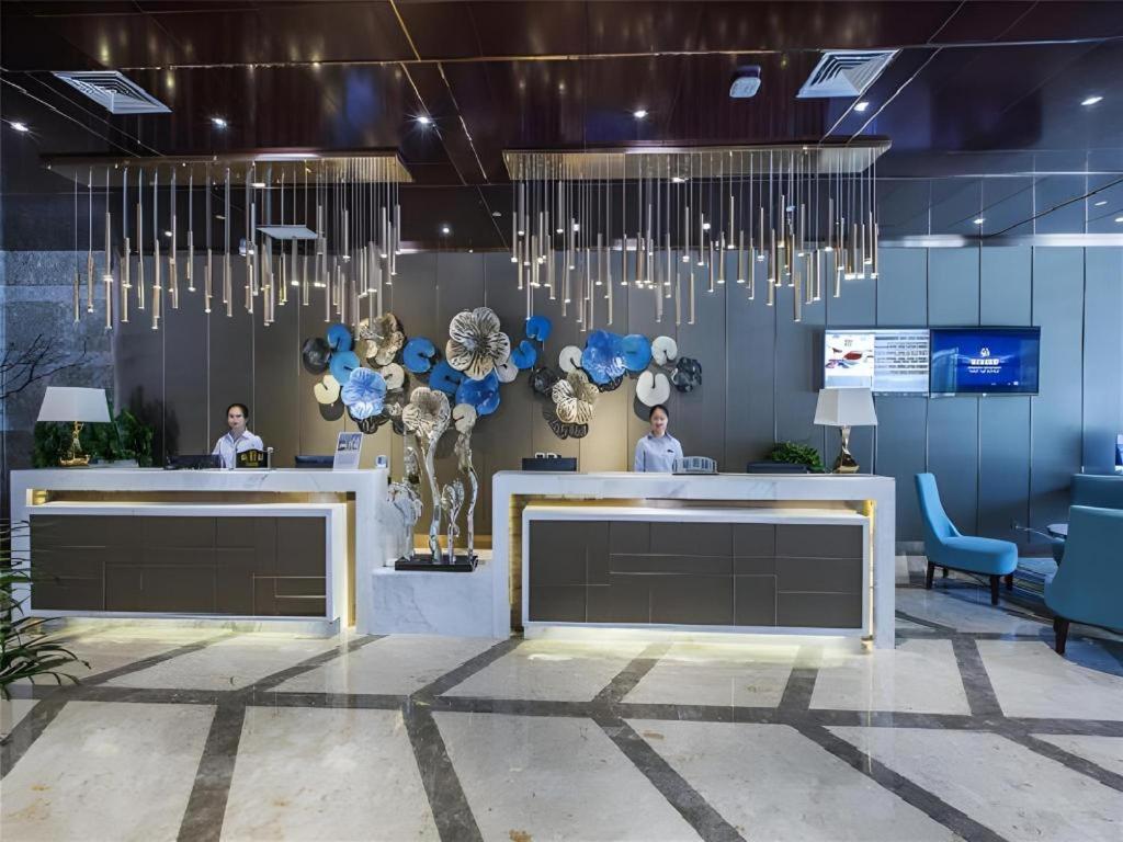 vestíbulo con recepción y lámparas de araña en Metropolo Hotel Yining Development Zone Hanma Building, en Yining Airport