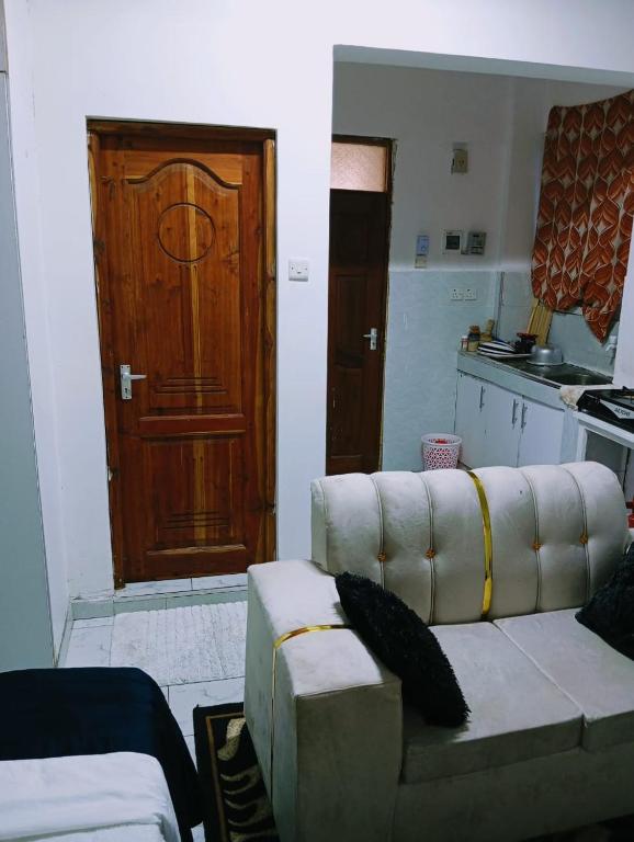 a living room with a couch and a wooden door at Talla Homes in Mombasa