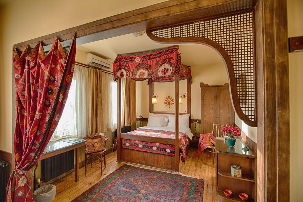 um quarto com uma cama de dossel num quarto em Hotel Empress Zoe em Istambul