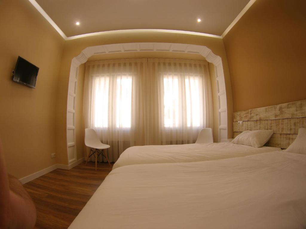 1 dormitorio con 2 camas y ventana en Urban Burgos, en Burgos