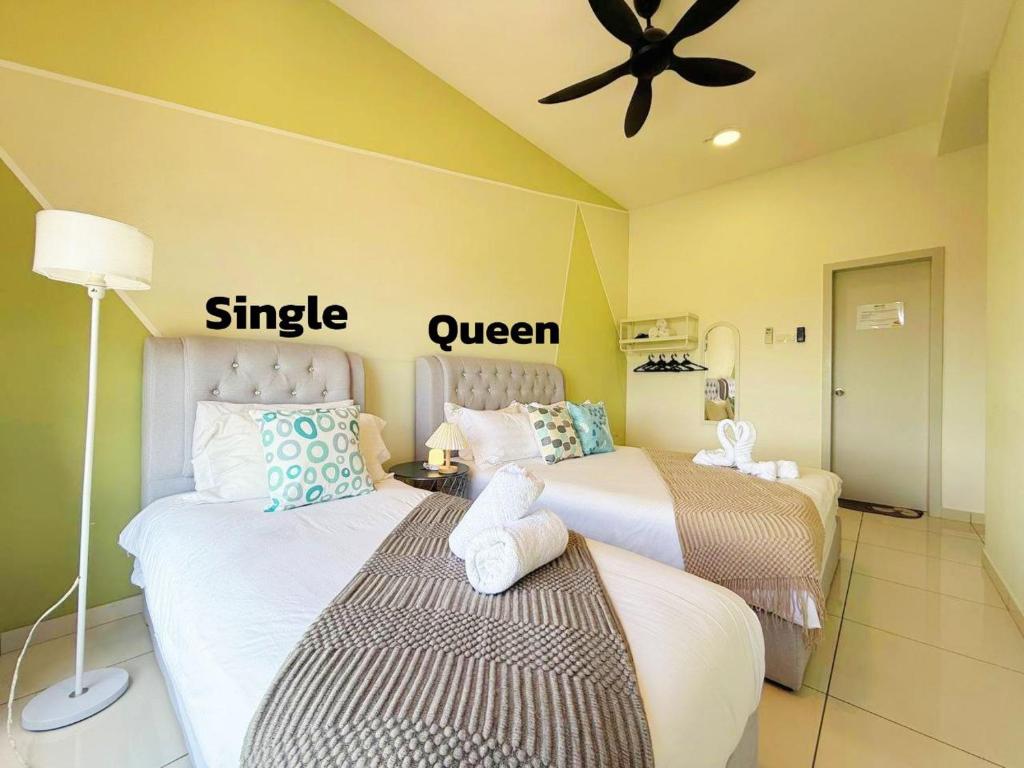 Un dormitorio con dos camas y un ventilador de techo. en The Horizon Ipoh 2BR L12 by Grab A Stay, en Ipoh