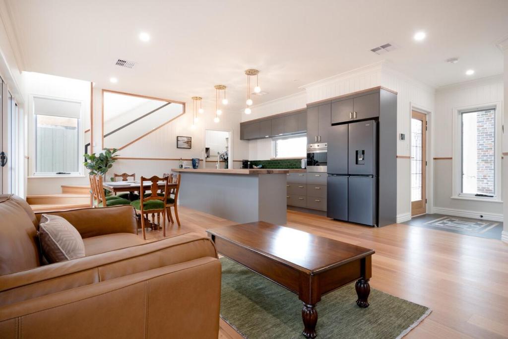 ローンセストンにあるPure Bliss - Comfort Delightのソファとテーブルのあるリビングルームとキッチン