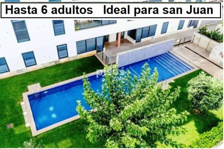 シウタデリャにあるApartamento Cala Busquets 6 pax ideal san Joanのスイミングプール付きの建物の空中ビュー