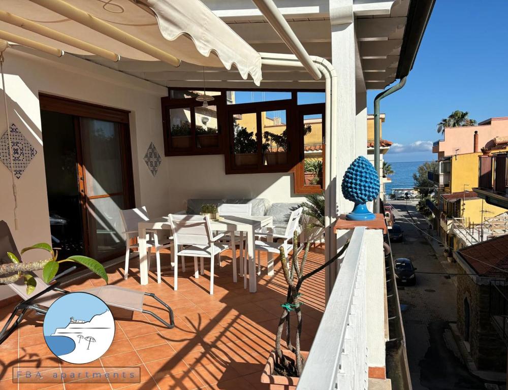 ein Balkon mit Tisch und Stühlen auf einem Gebäude in der Unterkunft Casa vacanze La Chicca in Capo dʼOrlando