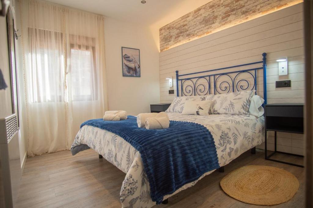 a bedroom with a bed with a blue and white blanket at SERENA Apartamento Cudillero in Cudillero