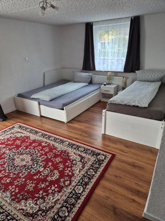 a bedroom with two beds and a rug on the floor at Ferienwohnung Selb in Selb