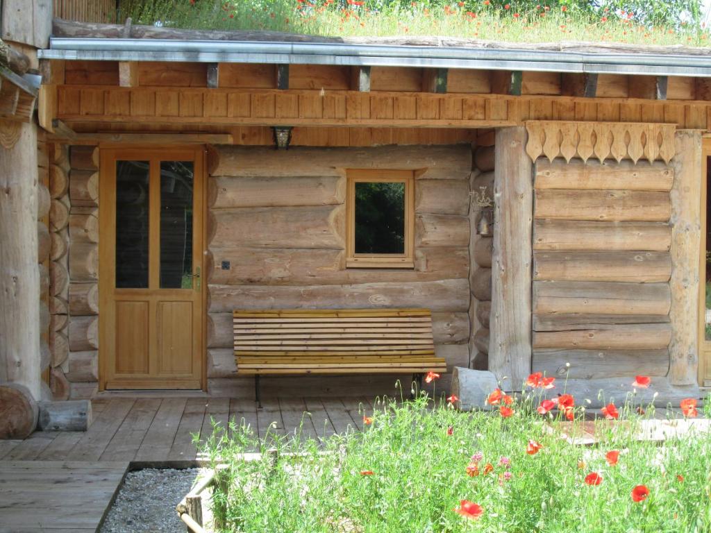 a wooden cabin with a bench and a door at La Fuste des Garceaux in Orconte