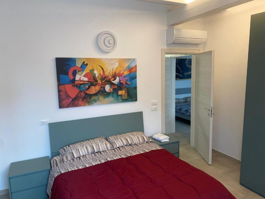 a bedroom with a red bed and a painting on the wall at La Tavernetta delle Terme Euganee in Montegrotto Terme