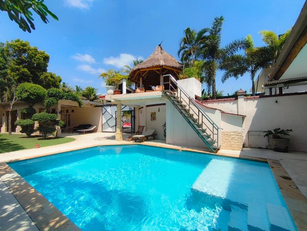 a swimming pool in front of a house at Loox Cozy Villa in Kalijaga