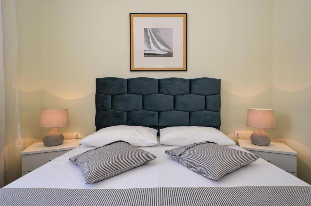 a bedroom with a large bed with two lamps at D&N Apartment in Kaštela