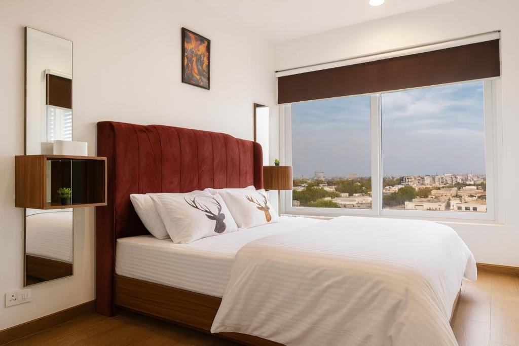 a bedroom with a bed with a large window at Penta Square Superior Executive Apartments-DHA Lahore in Lahore