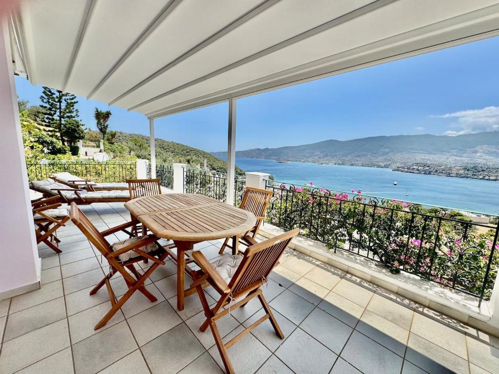 une table et des chaises sur un balcon avec vue sur l'océan dans l'établissement Poros Thea Villa, à Poros