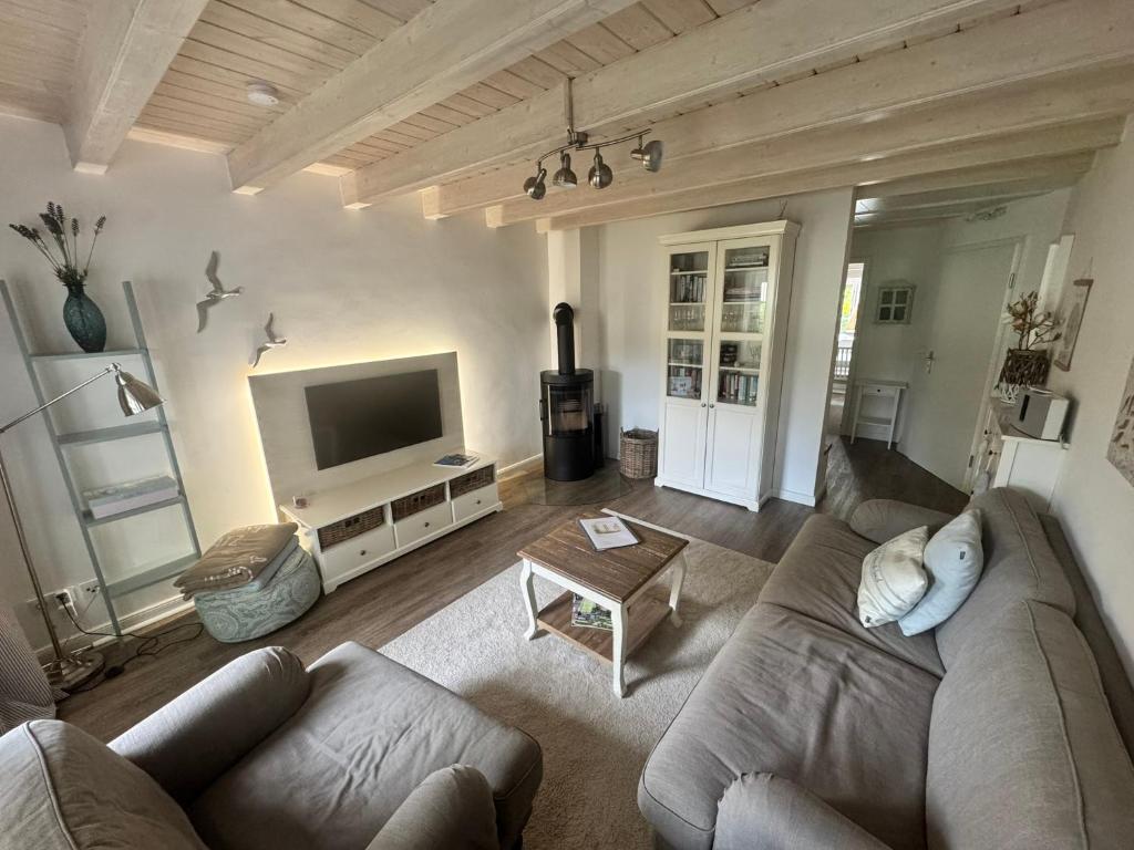 a living room with a couch and a tv at Lieblingsplatz in Wrixum