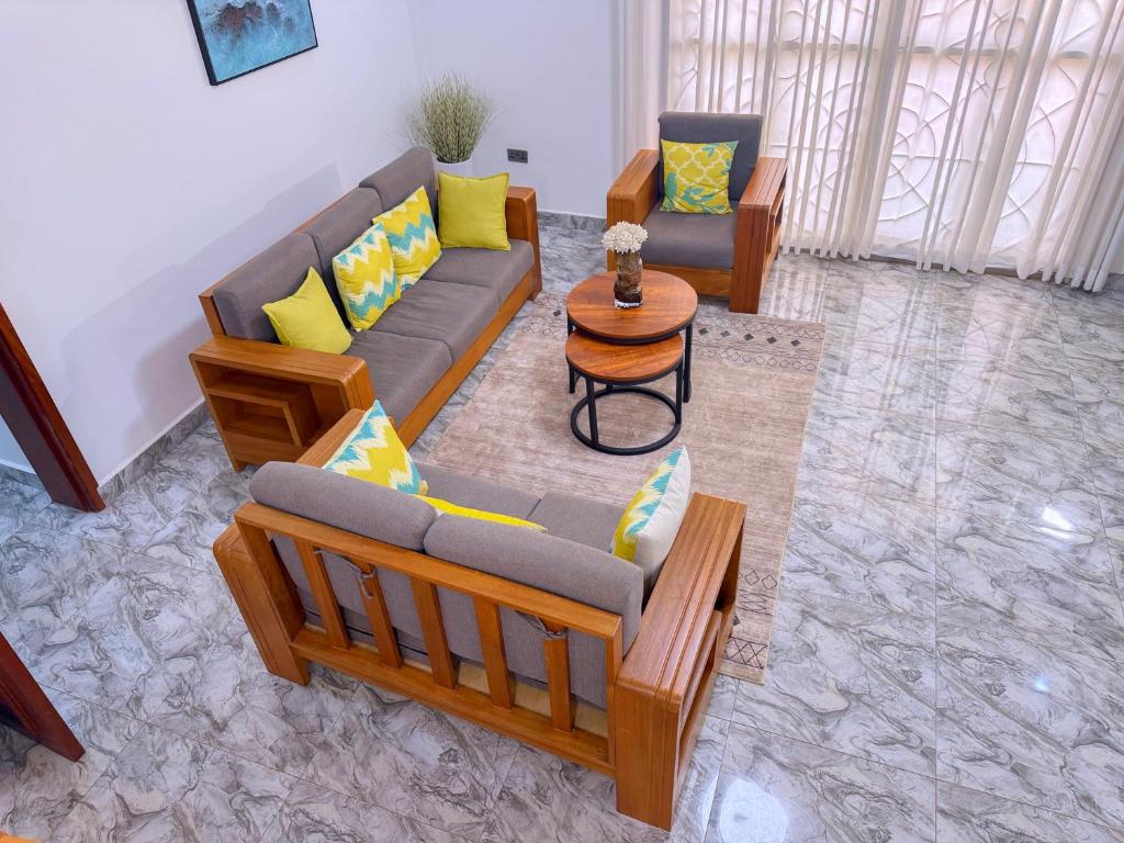 a living room with two couches and a table at Maja Apartments Kampala in Kampala