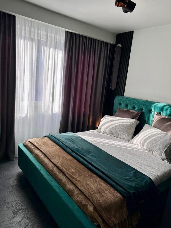 a bedroom with a green bed with a window at GZP Residence Lugoj in Lugoj
